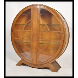 A 1930's Art Deco circular china display cabinet. The shaped plinth base with roundel display