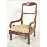 A 19th century Regency mahogany armchair. Raised on turned legs with loose cushion seat. Flanked