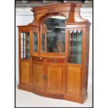 An Edwardian mahogany inlaid Arts & Crafts breakfront sentry box mirror back sideboard. Raised on