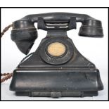 A vintage 20th century bakelite ring dial telephone. Raised on a square plinth base with sloped