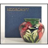 A Moorcroft ceramic vase tube lined decorated with flowers in the Anemone Tributte pattern