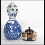 An Oriental Chinese ceramic double gourd vase of traditional blue and white form along with a