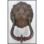 An early 20th century cast iron lion mask door knocker with remnants of original paint. Measures