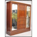 An Edwardian mahogany inlaid triple wardrobe compa