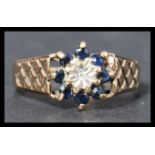 A hallmarked 9ct gold sapphire and diamond ring having a central illusion set diamond surrounded