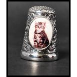 A 925 silver thimble with an enamel painted plaque depicting a cat. Marked 925. Weight 12.5g.