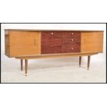 A 1950's retro laquered sideboard being raised on tapering legs with a series of drawers and