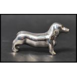 A cast sterling silver figure of a sausage dog. Marked Sterling. Measures 4cms. Weight approx 14.8g.