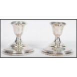 A pair of silver sterling candlesticks by Fisher. Each with circular bases and single sconces marked