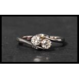 An 18ct white gold and platinum diamond ring having two approx 10pt diamonds in a crossover setting.