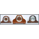 A group of three vintage 20th century wooden cased mantle clocks to include a walnut cased inlaid