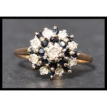 A hallmarked 9ct sapphire and diamond cluster ring having illusion set diamonds with round cut