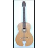 A vintage mid 20th century Italian Estudiantin acoustic guitar. The shaped hollow body having six