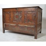An 18th century carved oak faux mule chest coffer. Being raised on stile legs with geometric panel