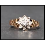 A hallmarked 9ct gold diamond cluster ring having a central illusion set diamond with a halo of