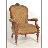 A Victorian mahogany aesthetic movement armchair. Raised on turned legs with overstuffed seat and
