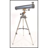 A vintage 20th century Celestron AstroMaster 76 telescope raised on an adjustable tripod base.