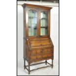 An early 20th century oak Jacobean revival bureau bookcase. Raised on barley twist supports with