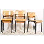 A collection of 16 retro panel wood and tubular metal stacking chairs. Each on ebonised tubular