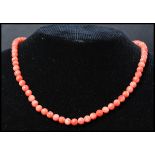 A vintage angel skin coral necklace. Each bead carved and strung set to a gilt barrel clasp.