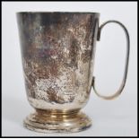 A hallmarked mid 20th century silver tankard cup raised on a circular base with C handle bearing