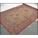 A large vintage Persian Islamic carpet rug having a red ground with geometric borders and