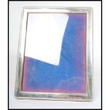 A large silver hallmarked easel picture frame, rope border, blue velvet back with central glass