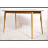 A fabulous retro vintage mid 20th century dining table raised on beech splayed legs, the table