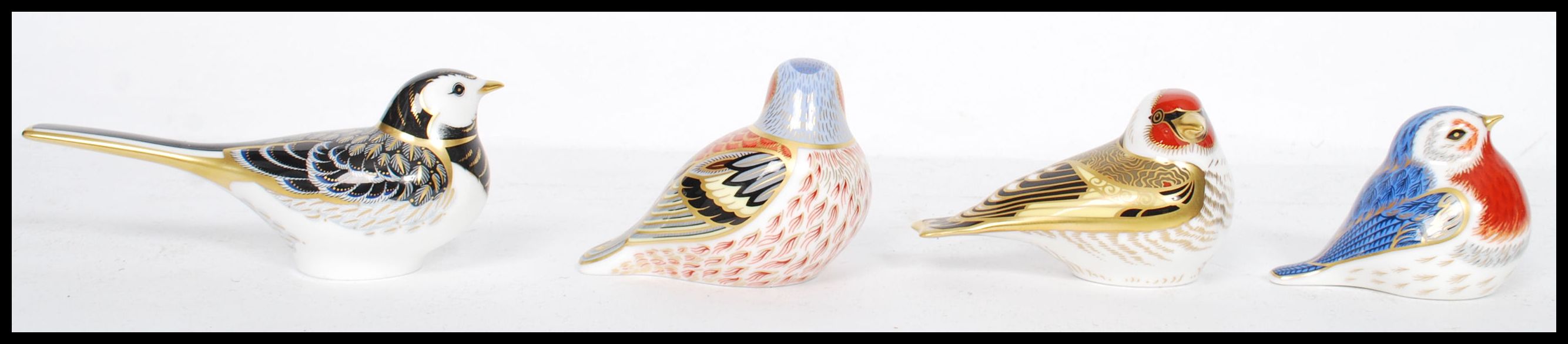 A collection of four Royal Crown Derby paperweights to include Chaffinch, Goldfinch, Anniversary