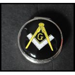 A 925 silver pill box having an enamel masonic motif to lid. Marked 925. Weight 16.9g. Measures 2.
