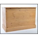 A contemporary pine blanket box raised on plinth base with panelled sides and hinged top opening