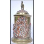 An early 20th century copper and brass biscuit tin / tobacco jar having a cherub and shield final