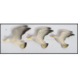 A group of three graduating ceramic wall plaques modelled as seagulls in flight impressed mark to