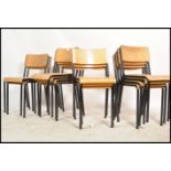 A collection of 13 retro panel wood and tubular metal stacking chairs. Each on ebonised tubular