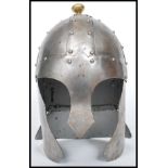 A reproduction Medieval 16th century style helmet of cast metal construction having a hammered and