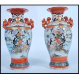 A pair of Japanese Kutani vases, Meiji, with twin handles modelled as dogs of fo, the panels
