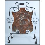 A 19th century Victorian Arts and Crafts wrought iron and copper fire screen depicting a dragon in