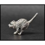 A cast sterling silver figure of a cat with emerald green eyes. Measures 4cms. Weight 13g.