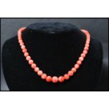 A vintage angel skin coral necklace. Each bead carved and strung set to a gilt barrel clasp.