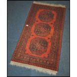 A 20th century Kelim woolen rug / runner , on red ground with a central medallion, inner border with