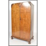 A 1930's Art Deco walnut bachelors wardrobe being raised on shaped leg plinth base with double doors