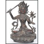 A 19th century cast metal figure of a seated eastern Tibetan Buddha raised on a stylised lotus