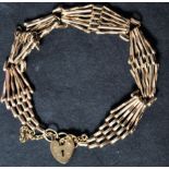 A hallmarked 9ct gold heart padlock clasp bracelet chain with safety chain. Weighs 9.1 grams.