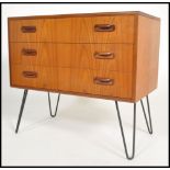 A vintage 20th century teak G-Plan chest of 3 drawers being raised on hairpin legs ( label to inside