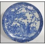 A 19th century blue and white Chinese ceramic charge plate depicting domestic scenes of elders