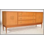 A 1970's retro teak wood sideboard of low and wide form being raised on tapered with a bank of