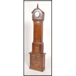 A 19th century oak cased continental  grandmother clock raised on a later built cupboard plinth
