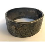 A  hallmarked silver aesthetic movement bangle bracelet decorated with oriental ships and birds.