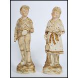 A figural group of 2 early 20th century continental bisque slip moulded tennis figures, one a boy,