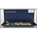 A Moorcroft ceramic pin tray of rectangular form tube lined decorated with flowers complete in